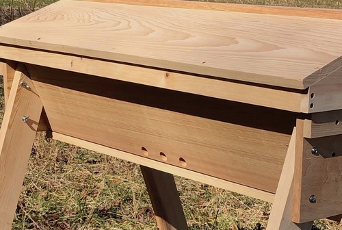 The location of the 3 one-inch entrances in the center of the long side of the Gold Star top bar hive means that this is a "side center entrance" style of top bar hive.  This supports the simple hiving of bees in cold weather due to the air space created on the far side of the two follower boards.